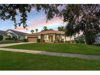 Charming single story home featuring a well maintained lawn, mature landscaping, and a two-car garage at 16627 Rockwell Heights Ln, Clermont, FL 34711