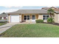 Charming single-story home featuring an attached garage and well-maintained front lawn at 1711 Tropical Ct, Tavares, FL 32778