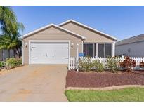 Charming single-story home featuring a well-maintained lawn and a one car garage at 1817 Orange Ct, The Villages, FL 32162