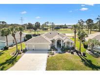 Beautiful home with a three-car garage and attractive landscaping, backing onto a lush golf course at 1840 Madero Dr, The Villages, FL 32159