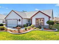 Charming single-story home featuring a well-manicured lawn and a meticulously landscaped front yard at 1914 Antonia Pl, The Villages, FL 32159