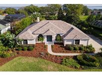 Stunning home featuring a beautiful front yard, well-manicured landscaping, and a charming blue front door at 39136 Harbor Hills Blvd, Lady Lake, FL 32159