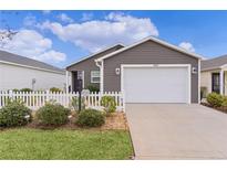 Charming single-story home with a white picket fence and well-maintained landscaping at 5597 Gracie Ln, The Villages, FL 32163