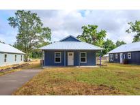 Charming blue single-story home with a metal roof and covered porch, offering classic curb appeal at 654 Nw 9Th Ave, Webster, FL 33597