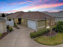 Beautiful single-story home featuring a well-manicured lawn and a two car garage under a vivid sunset at 796 Elliott Ave, The Villages, FL 32163