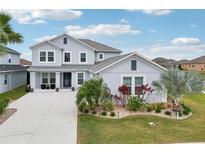 Beautiful two-story home with manicured landscaping, light blue exterior paint and matching shutters at 977 Timberview Rd, Clermont, FL 34715