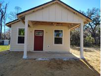 Charming new home construction featuring a cozy front porch and modern design elements at Lot 15 Indian Estates Cr 423, Lake Panasoffkee, FL 33538