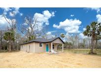 Charming single-story home with a covered porch and a bright blue front door at Lot 19 Indian Estates Cr 423, Lake Panasoffkee, FL 33538