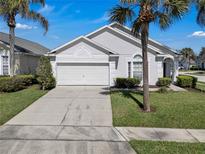 Charming single-story home features a two-car garage, well-maintained landscaping, and mature palm trees at 16739 Hidden Spring Dr, Clermont, FL 34714