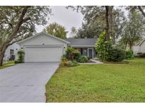 Charming single-story home featuring a two-car garage and well-maintained landscaping at 210 Palermo Pl, Lady Lake, FL 32159