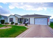 Charming single-story home with well-manicured landscaping, a two-car garage and an inviting front entrance at 2682 Edwards Ln, The Villages, FL 32162