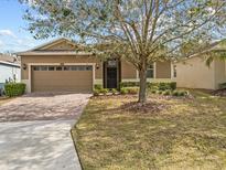 Charming single-story home featuring a well-maintained lawn and a two-car garage with brick-paver driveway at 3808 Serena Ln, Clermont, FL 34711