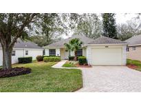 Charming single-story home features a manicured front yard, paver driveway, and attached two car garage at 3847 Eversholt St, Clermont, FL 34711