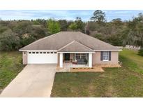 Charming single-story home featuring a well-maintained lawn and a welcoming covered front porch at 40707 E Ninth Ave, Umatilla, FL 32784