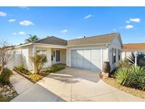 Charming single-story home featuring an attached two-car garage, and a well-manicured landscaped yard with beautiful plants at 544 Audrey Ln, The Villages, FL 32162