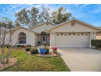 Charming home featuring a well-maintained lawn and an attached two-car garage at 544 Grand Vista Trl, Leesburg, FL 34748