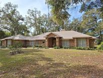 Charming single-story brick home with a well-manicured front yard and mature trees at 580 Mercers Fernery Rd., Deland, FL 32720