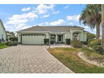 Charming single-story home with a two-car garage, a well-manicured lawn, and a paved driveway at 602 Catalina Ct, Lady Lake, FL 32159