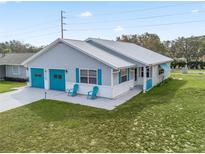 Charming single-story home featuring a metal roof, two-car garage, and well-manicured lawn at 701 Brigadoon Cir, Leesburg, FL 34788