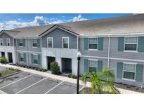 Charming townhouse with gray siding, teal shutters, and well-maintained landscaping at 7581 Oak Spring Ln, Davenport, FL 33837