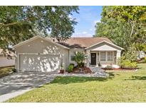 Charming single-story home with a well-maintained lawn and attached two-car garage at 1212 Windy Bluff Dr, Minneola, FL 34715
