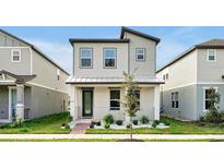 Modern two-story home showcasing contemporary design and landscaped front yard for curb appeal at 140 S Zuni Rd, St Cloud, FL 34771