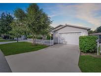 Well-maintained home with a two-car garage, long driveway, and manicured lawn at 16865 Se 94Th Sunnybrook Cir, The Villages, FL 32162
