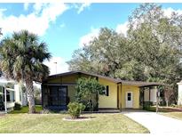 Charming single-story home with a covered carport, screened porch, and lush green lawn at 224 Westwood Dr, Leesburg, FL 34748