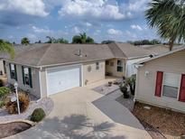 Charming single-story home featuring a two-car garage and a well-manicured lawn, creating a welcoming curb appeal at 2367 Camden Ter, The Villages, FL 32162