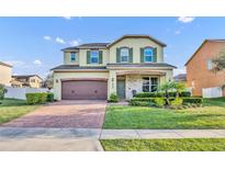 Charming two-story home featuring a brick-paved driveway, manicured lawn, and an inviting front porch at 2727 Retriever Dr, Clermont, FL 34711