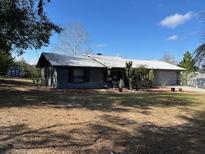 Attractive single-story home with a metal roof, lovely landscaping, and a spacious front yard at 37149 Grays Airport, Lady Lake, FL 32159