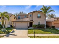 Two story home featuring an attached two car garage and well-manicured lawn at 412 Arbor Pointe Ave, Minneola, FL 34715