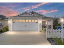 Charming single-story home featuring a two-car garage, screened porch, and manicured landscaping at 5432 Todd Ct, The Villages, FL 32163