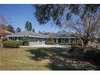 Charming one-story home featuring a manicured front lawn and a spacious driveway at 10648 Lake Hill Dr, Clermont, FL 34711
