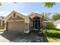 Charming single-story home featuring an attached garage and well-maintained landscaping with American Flag at 10910 Rushwood Way, Clermont, FL 34714