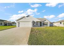 Charming single-story home with a well-manicured lawn and attached two-car garage at 12050 Ne 51St Cir, Oxford, FL 34484