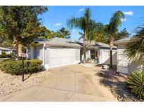 Charming home featuring a two-car garage, well-manicured landscaping, and a welcoming entrance at 1952 Peachtree Ave, The Villages, FL 32162