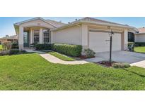 Charming single-story home featuring a well-manicured lawn and a two-car garage at 27536 Stoney Brook Dr, Leesburg, FL 34748