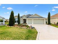 Charming single-story home featuring a well-manicured lawn, tasteful landscaping, and a spacious three-car garage at 3233 Belcherry Loop, The Villages, FL 32163