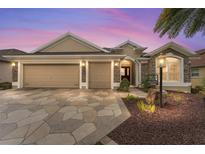 Charming home featuring a two-car garage, stone accents, and a well-maintained landscape at 3342 Queensway Ter, The Villages, FL 32163