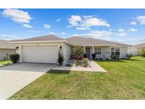 Charming single-story home featuring a well-manicured lawn and attached two-car garage at 4000 Se 98Th Pl, Belleview, FL 34420