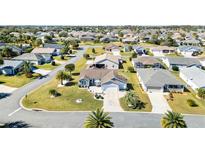 Expansive aerial view of a vibrant residential community with well-maintained lawns and mature landscaping at 909 Abaco Path, The Villages, FL 32163