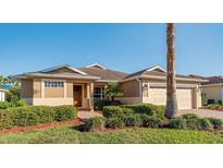 Charming single-story home featuring a manicured lawn, two-car garage, and neutral tones at 10105 Ketch Kay Ln, Oxford, FL 34484