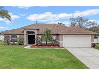 Charming single-story home with a well-manicured lawn and a two-car garage at 2214 Lake Pointe Cir, Leesburg, FL 34748