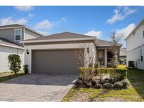 Charming single-story home featuring a two-car garage and a well-manicured lawn on a sunny day at 2365 Palm Park Loop, Clermont, FL 34714