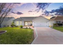 Charming one-story home featuring manicured lawn, lovely landscaping, and a two-car garage at 3176 Atwell Ave, The Villages, FL 32162