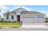 Charming single-story home featuring a three-car garage and well-manicured lawn at 7193 Dilly Lake Ave, Groveland, FL 34736