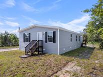 Charming single-story home with gray siding, black shutters, and a welcoming front porch at 909 Lake Thomas Rd, Lake Wales, FL 33898