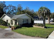 Charming one story commercial building featuring well maintained lawn, palm tree and elegant signage at 911 N Donnelly St, Mount Dora, FL 32757