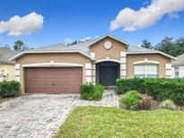 Charming single Gathering home featuring a well manicured lawn, beautiful brick driveway and two car garage at 1007 Balmoral Dr, Davenport, FL 33896